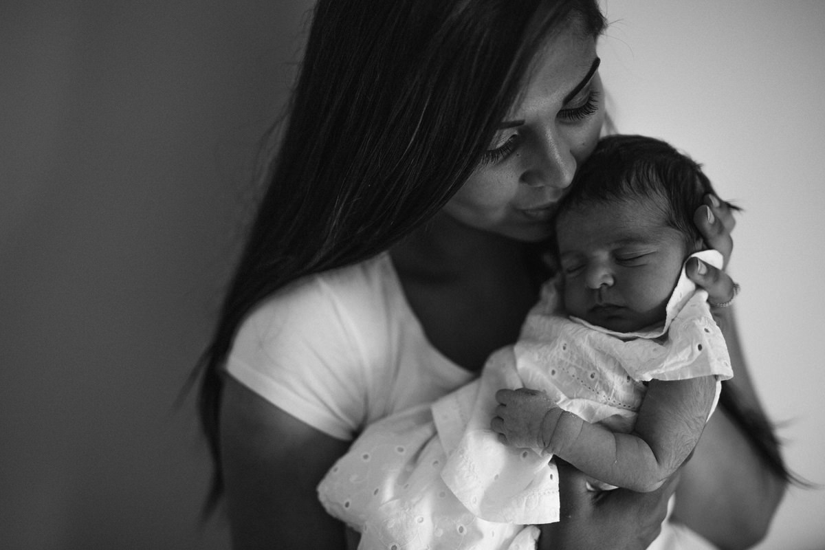 moody black and white kiss newborn family snuggle on the bed lifestyle photography yasmin anne