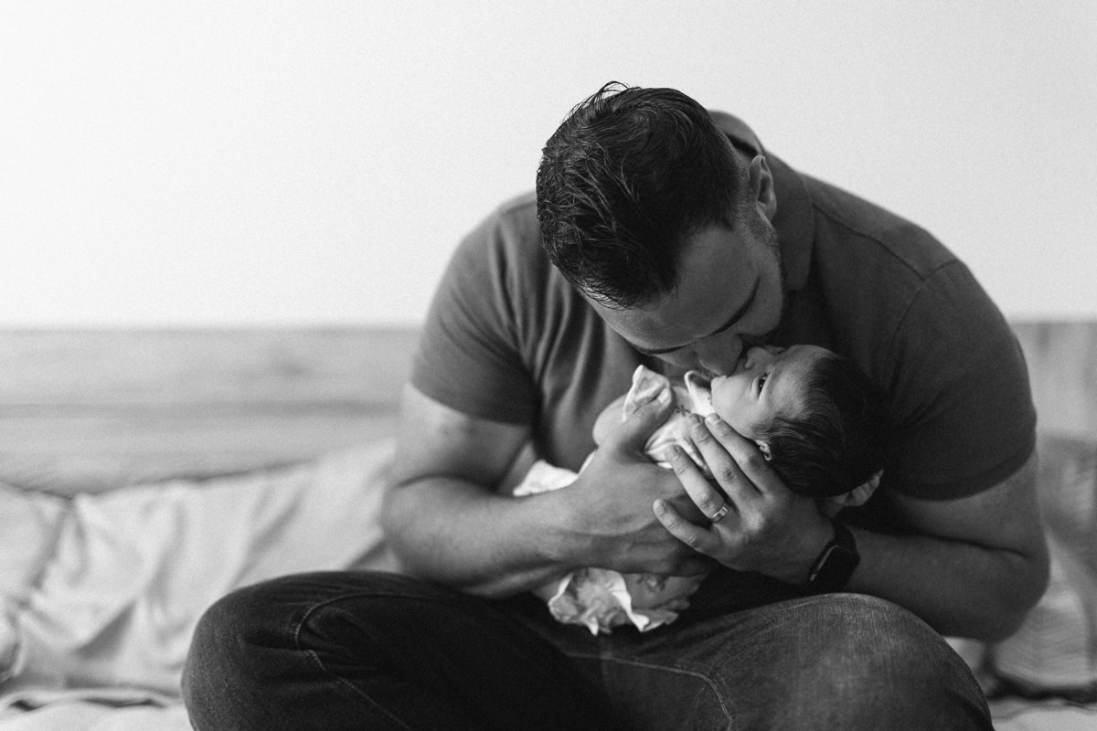 black and white kisses newborn family snuggle on the bed lifestyle photography yasmin anne