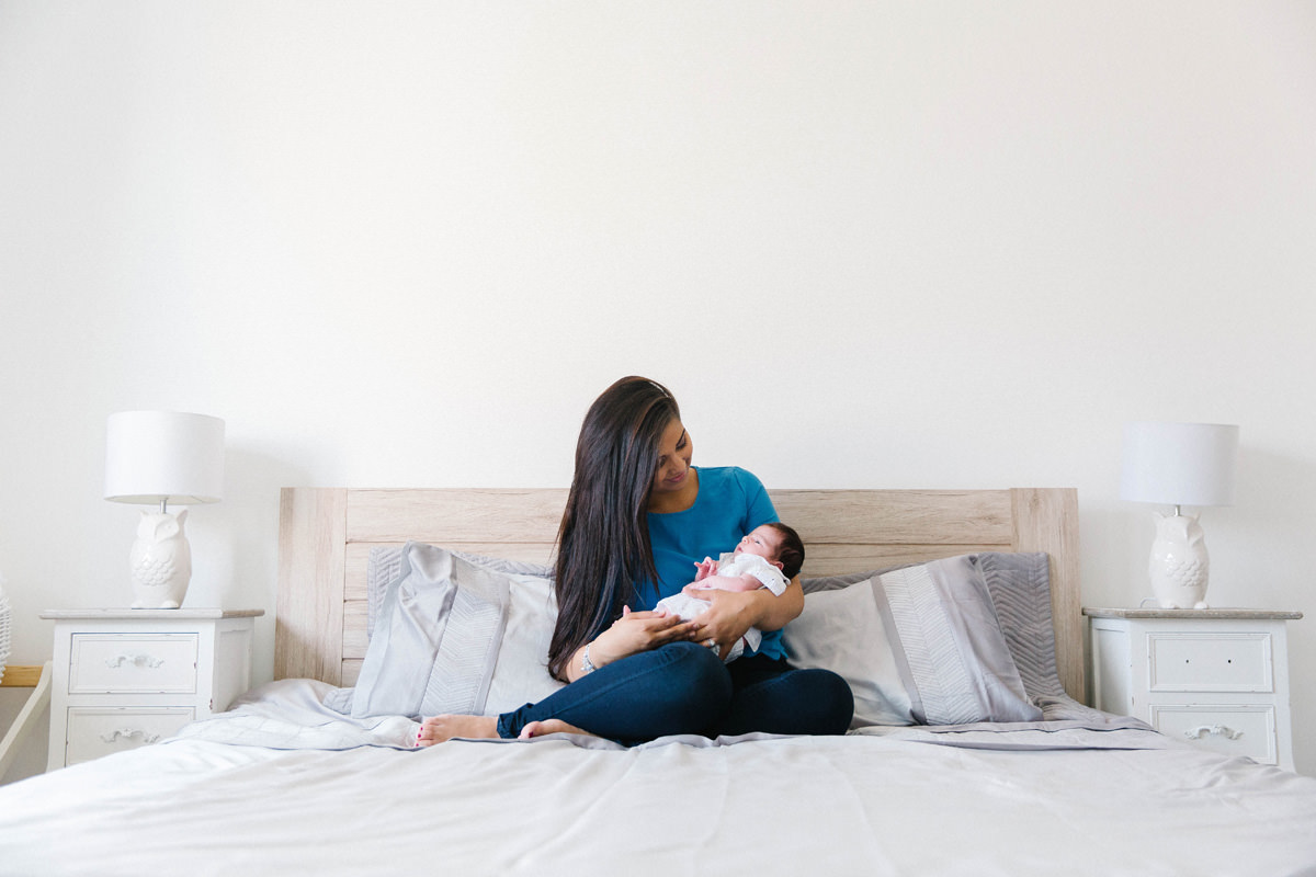 mummy kisses newborn family snuggle on the bed lifestyle photography yasmin anne