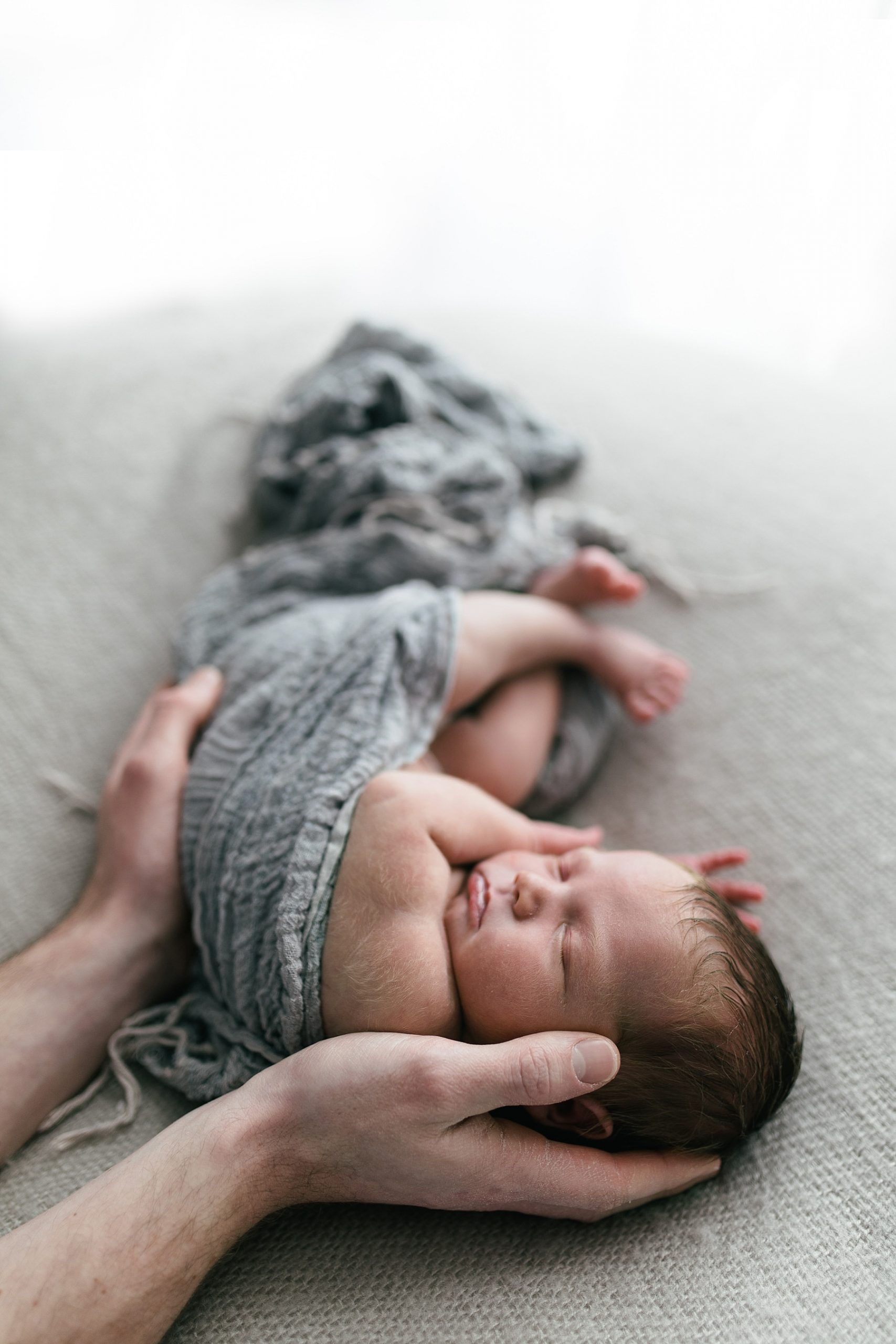 dad holding newborn baby photoshoot in white studio natural photography