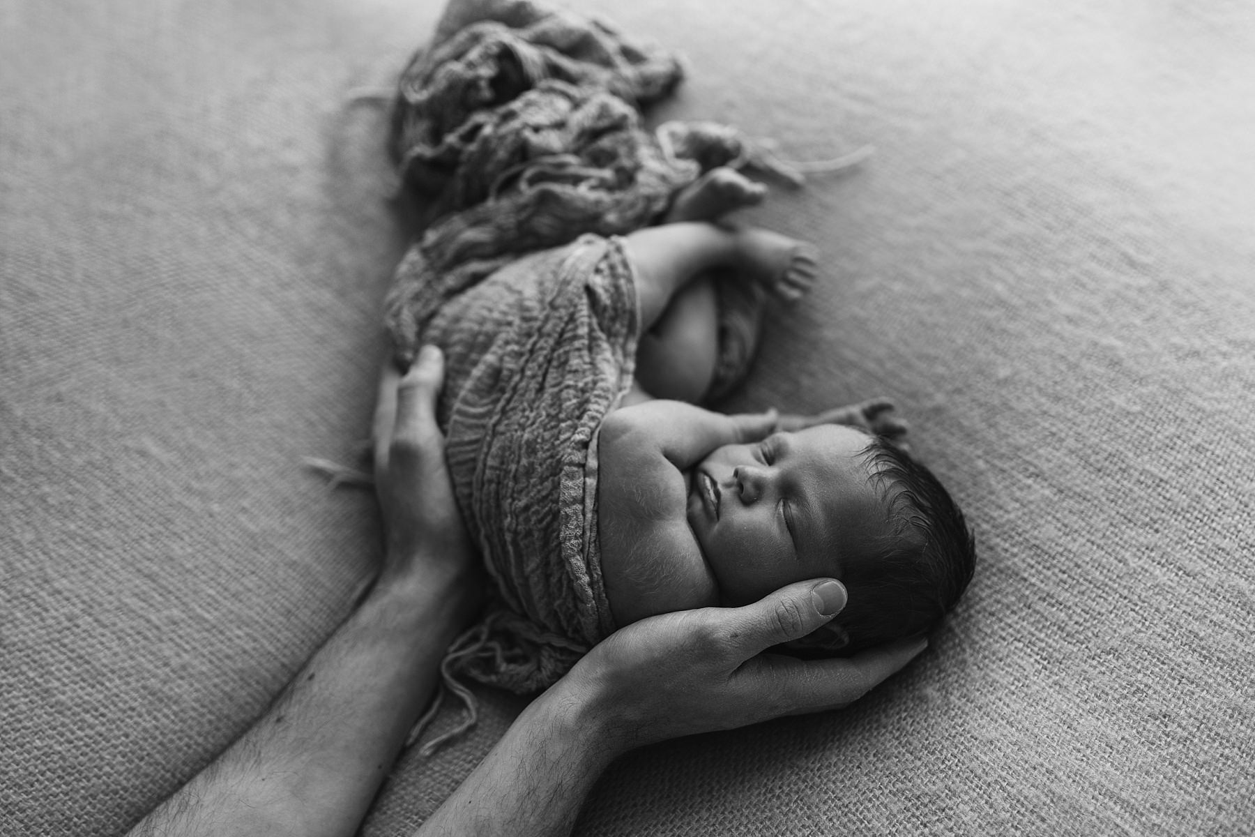 dad holding newborn baby photoshoot in white studio natural photography