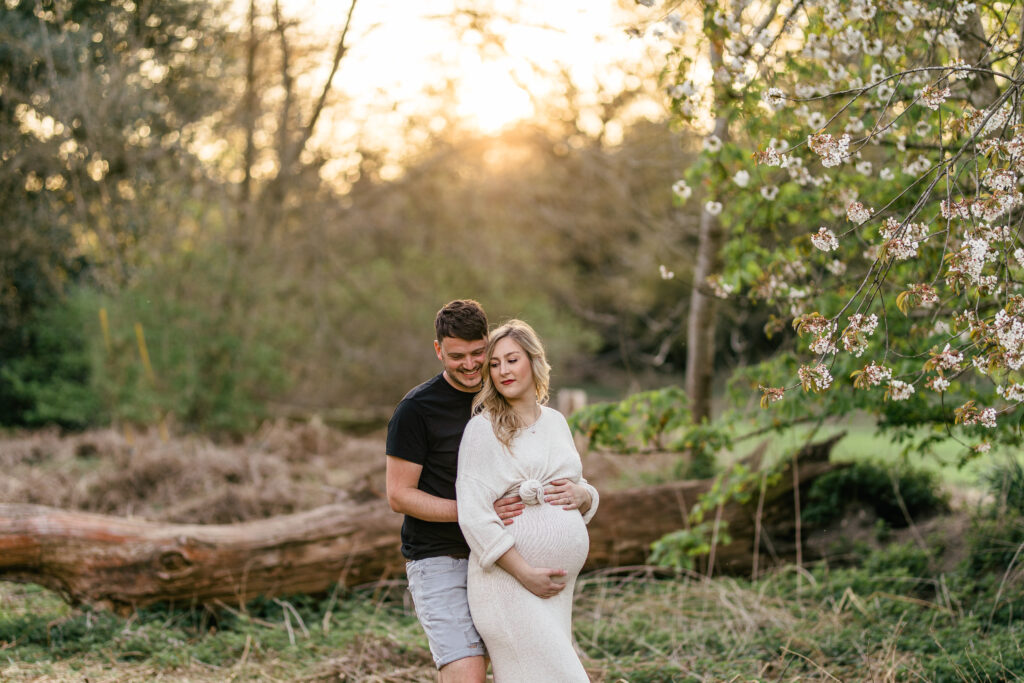 sunset maternity photoshoot with husband and mother to be and spring blossoms