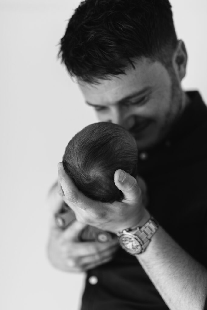 Dad holds baby and smiles 