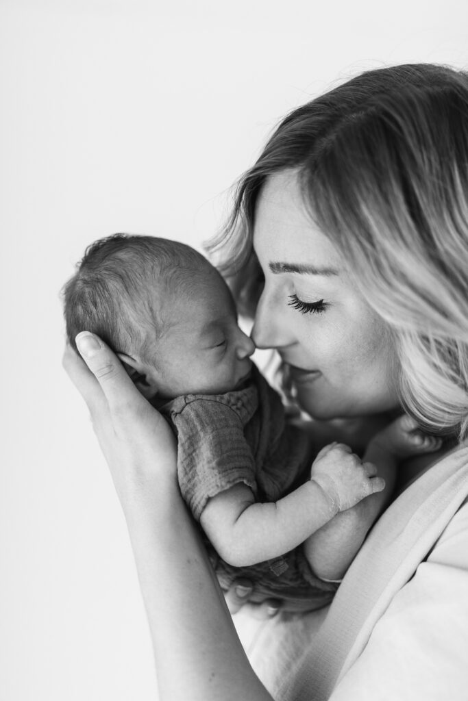 mum rubs nose with newborn baby and smiles