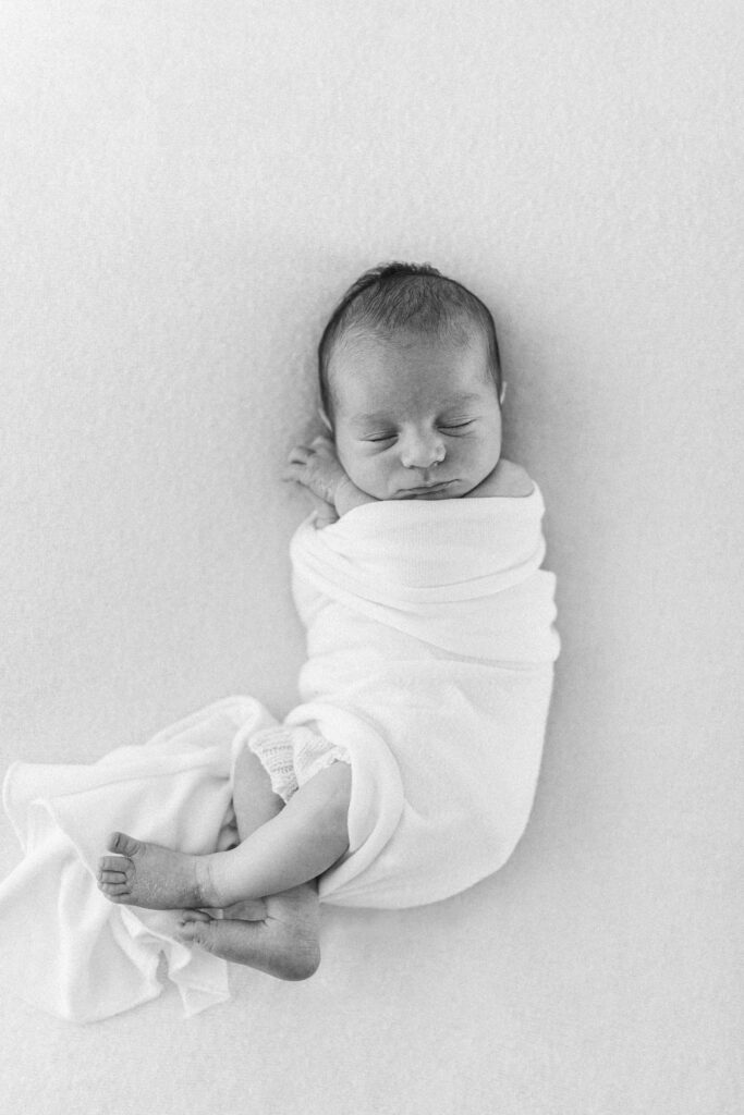 Swaddled baby asleep on the bed 