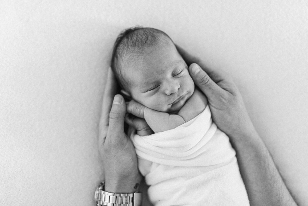 Dad holds baby in his hands 