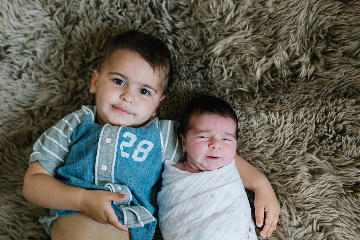 arm around brother and sister family snuggle on the bed lifestyle photography yasmin anne