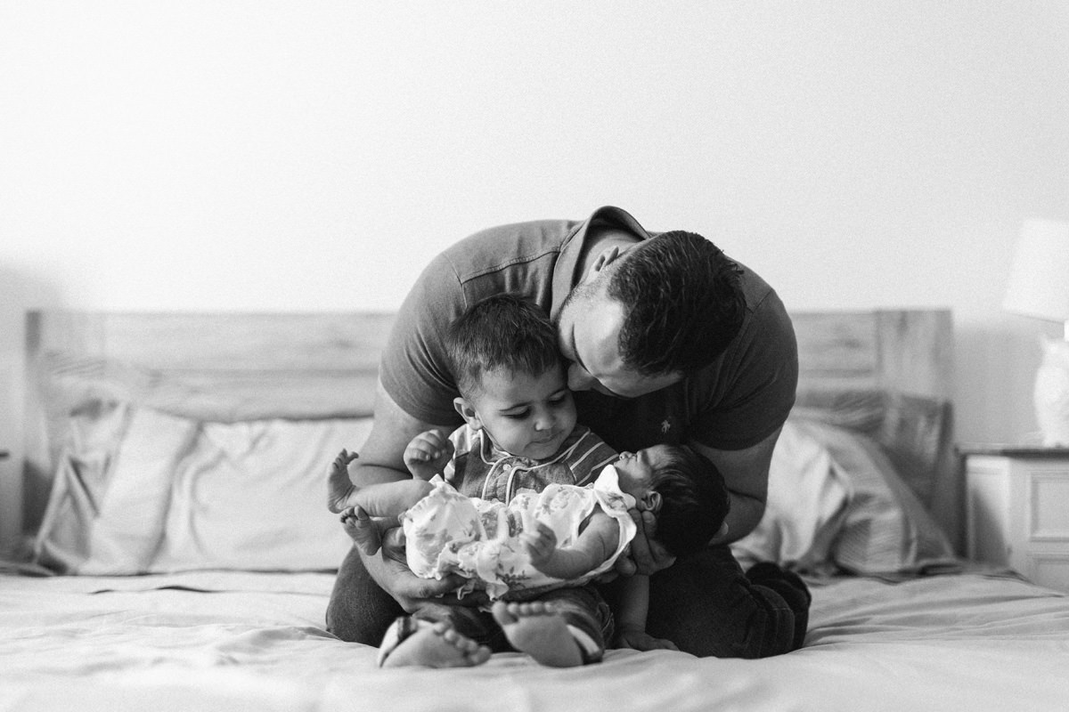 black and white family snuggle on the bed lifestyle photography yasmin anne