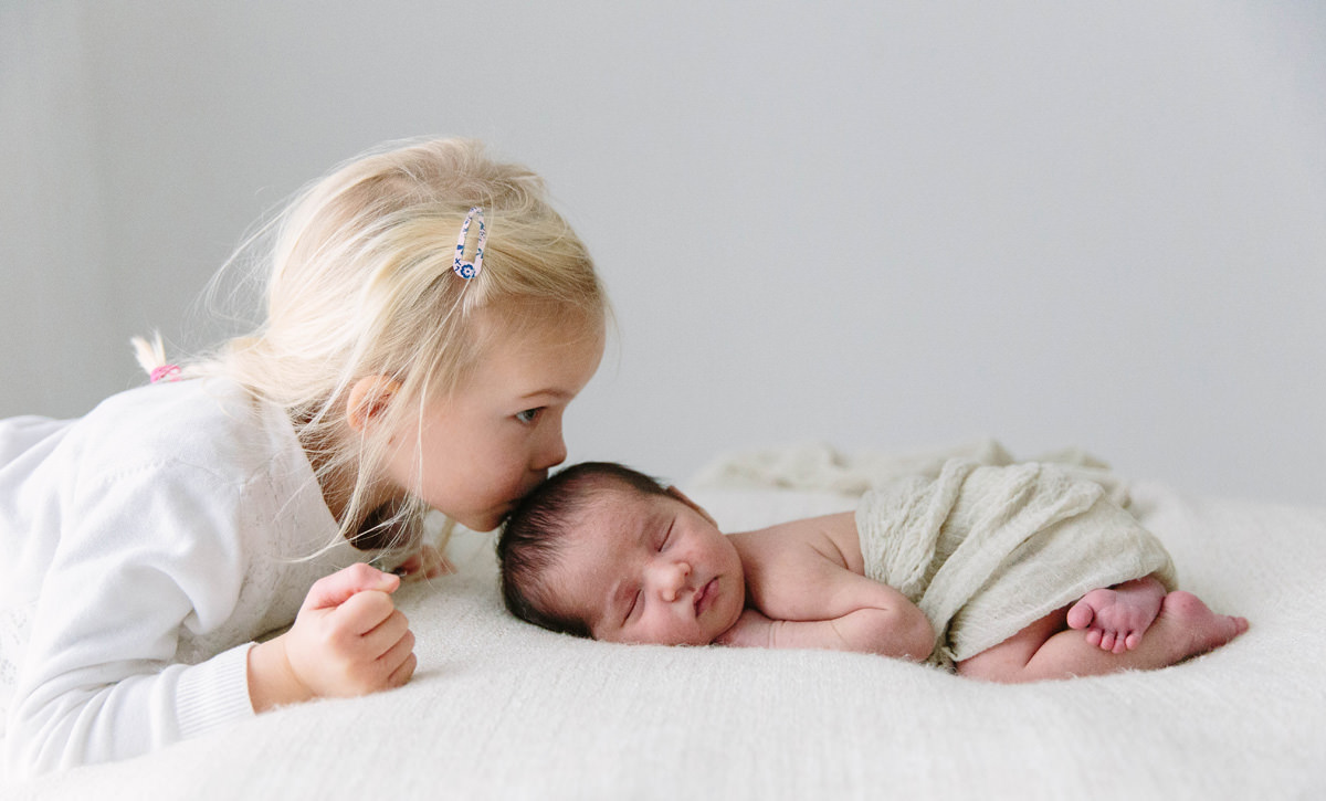 little girl kisses her newborn brother yasmin anne photography berkshire hampshire surrey