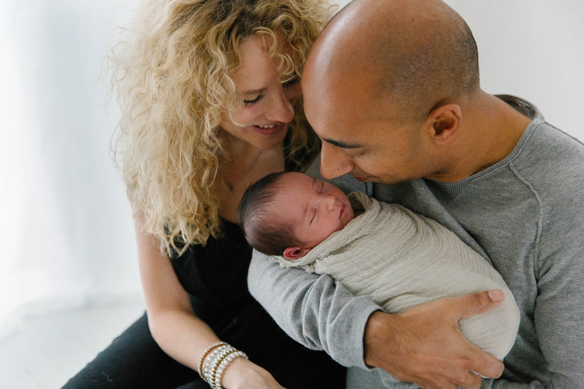 proud parents kiss newborn baby boy on head yasmin anne photography berkshire hampshire surrey